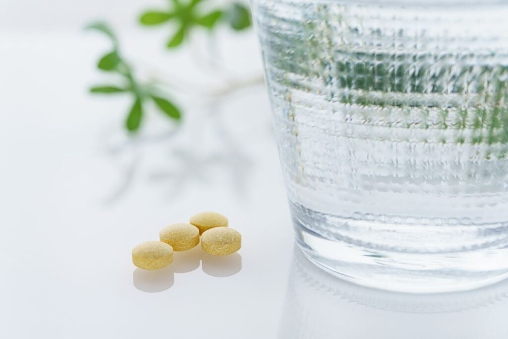 Vitamin tablets and water symbolizing supplements that support IV Therapy for Hydration and recovery.